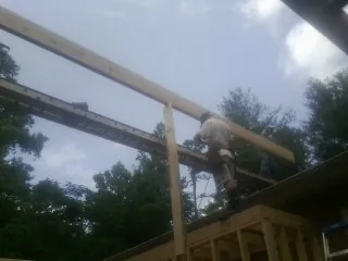 Carpenter setting a ridge beam over a new addition frame — Ice Dam Removal by Roofing Brothers in Dillsboro